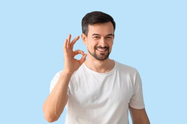 Yakışıklı adam mavi arka planda iyi görünüyor