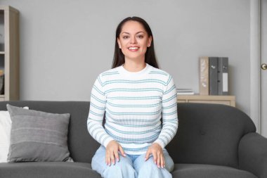 Genç bir kadının evde görüntülü konuşması.