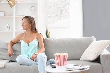 Genç bayan izin gününde evde dinleniyor.