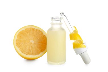 Beyaz zemin üzerinde limon olan bir şişe C vitamini.