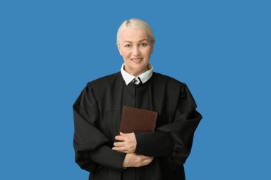 Mavi arka plan kitabı olan olgun bir kadın yargıç.