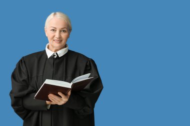 Mavi arka plan kitabı olan olgun bir kadın yargıç.