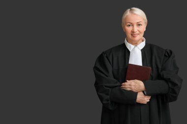 Siyah arka plan kitabı olan olgun bir kadın yargıç.