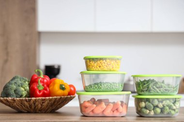 Mutfaktaki ahşap masada taze ve donmuş sebzeler.