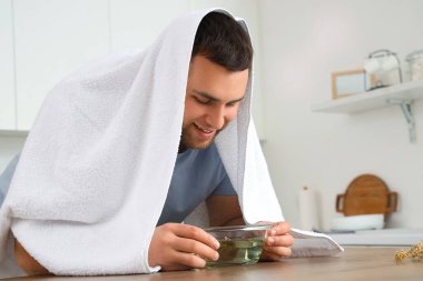 Genç adam mutfakta buhar solumuş.