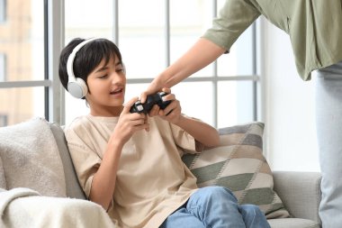 Kızgın anne, evdeki ergen oğlundan oyun kağıtlarını alıyor. Aile sorunu kavramı