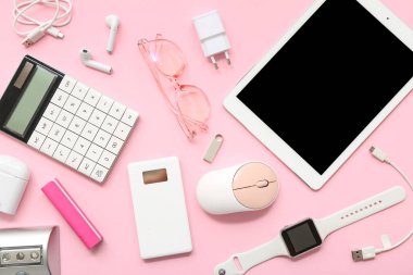 Pembe arka planda farklı modern cihazlar ve gözlüklerle kompozisyon