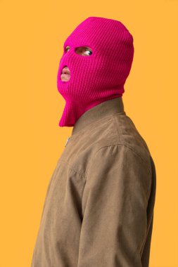 Sarı arka planda kar maskeli yakışıklı bir genç.