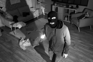 Male thief with flashlight in room at night, view through security camera clipart