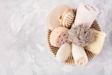 Açık arkaplanda farklı banyo aksesuarları olan sepet.