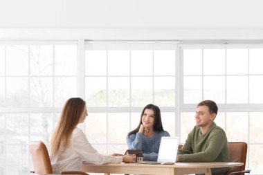 Ofiste çiftlerle çalışan bir emlakçı.