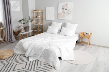 Duvarında resimler olan şık bir yatak odası.