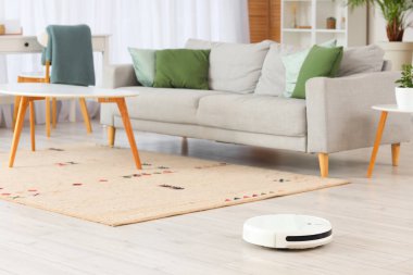 Robot süpürgesi oturma odasında yerde.
