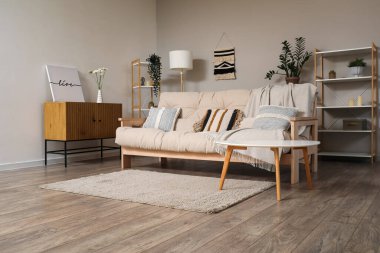 Oturma odasında halısı ve kahve masası olan şık bej bir kanepe.