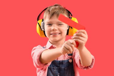 Kırmızı arka planda cetveli olan şirin bir inşaatçı.