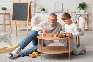 Büyükbaba evde sevimli küçük torunuyla oynuyor.