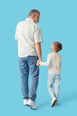 Mavi arka planda, sevimli küçük torunu olan büyükbaba.