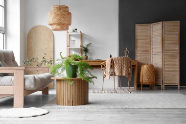 Işıl ışıl oturma odasında gri kanepe ve ahşap masa ile sıcak bir iç mekan.