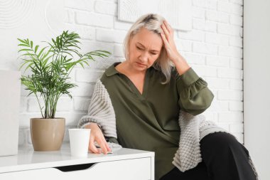 Ofiste menopoz geçiren yetişkin bir iş kadını.