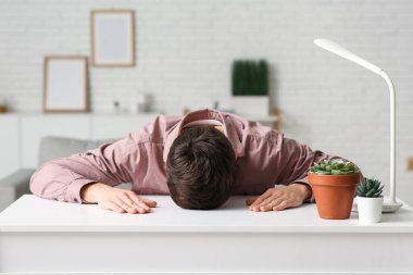 Odada uyuyan yorgun genç adam.