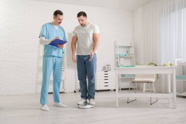 Pul üzerinde genç bir adam klinikte beslenme uzmanını ziyaret ediyor.