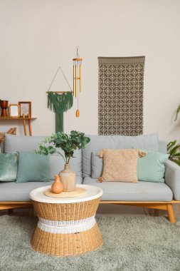 Oturma odasının içinde rüzgar çanı, kanepe ve masa.