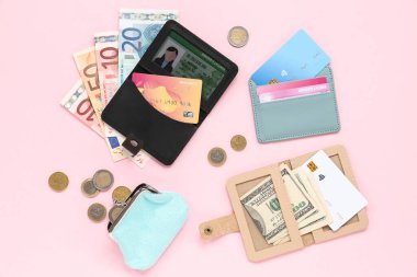 Kredi kartı, ehliyet, cüzdan ve pembe arka plandaki paralı kompozisyon, yakın plan.