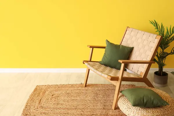 靠近黄墙的有扶手椅 脚垫和靠垫的客厅室内 图库图片