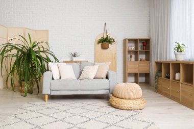 Kanepesi, raf ünitesi ve çiçekli şık beyaz oturma odası.