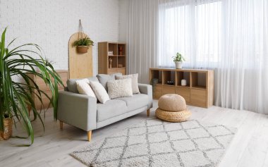 Kanepesi, raf ünitesi ve çiçekli şık beyaz oturma odası.