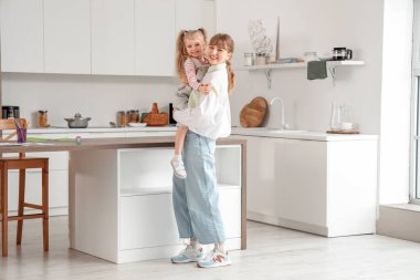 Dadı küçük kızı mutfakta tutuyor.