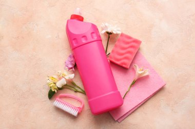 Bej renginde temizlik malzemeleri ve bahar çiçekleri.