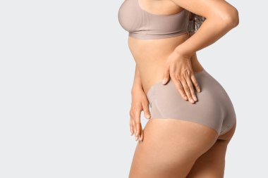 İç çamaşırlı genç kadın arka planda, yakın plan.