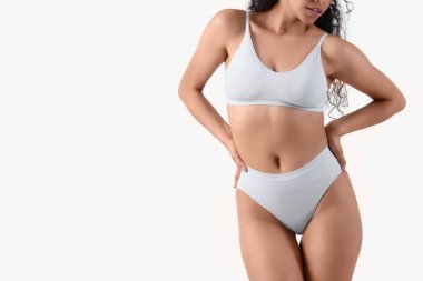 İç çamaşırlı, parlak arkaplanda genç bir kadın.