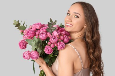 Güzel bir genç kadın, arka planda güller, yakın plan.