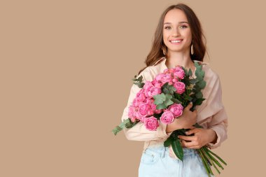 Kahverengi arka planda gülleri olan güzel genç bir kadın.