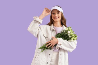 Leylak arka planında Eustoma çiçekleri olan güzel genç bir kadın.