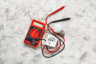 Beyaz grunge arka planda çoklu metre, ampul ve elektrik soketi