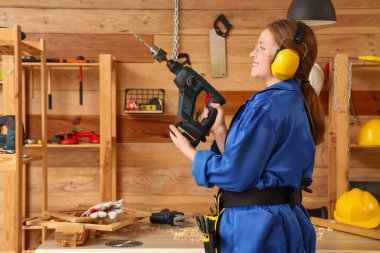 Atölyede matkabı olan genç bir kadın marangoz. İşçi Bayramı kutlamaları