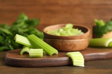 Ahşap zemin üzerinde taze yeşil kereviz kesilmiş yemek ve kase.