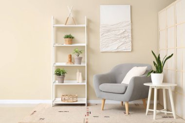 Rahat koltuğu, sehpası ve çiçeğiyle oturma odasının içinde.