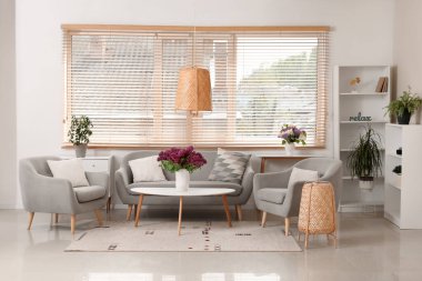 Oturma odasındaki sehpada leylak çiçekleri.