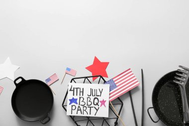 Gri arkaplanda Bağımsızlık Günü kutlamaları için 4 Temmuz barbekü partisi, barbekü aletleri ve dekor yazılı kart