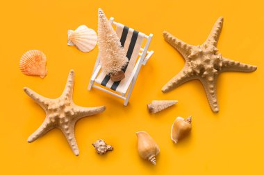 Minik güverte sandalyesi, Noel ağacı ve sarı arka planda deniz dekoru olan kompozisyon