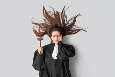 Tokmağı beyaz arka planda uzanmış ciddi genç bayan yargıç.