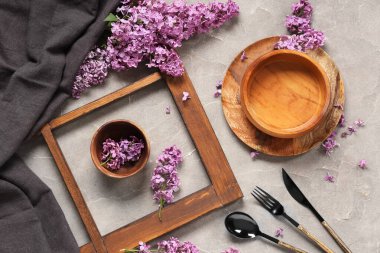 Gri grunge arka planında leylak çiçekleri olan güzel bir masa.