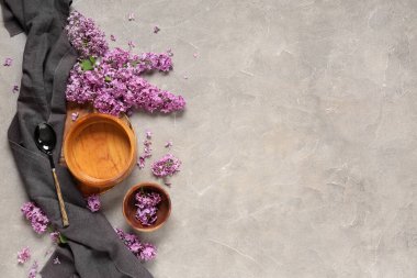 Gri grunge arka planında leylak çiçekleri olan güzel bir masa.