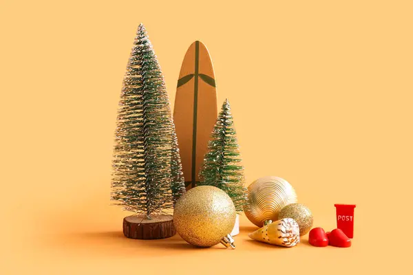 圣诞装饰品和彩色背景迷你冲浪板的构图 免版税图库照片