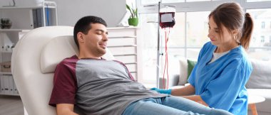 Klinikte genç donörden kan alan kadın hemşire.