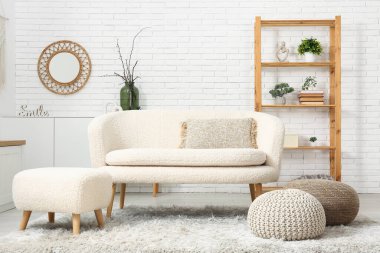 Rafları, kanepesi ve pufları olan modern oturma odasının içinde.